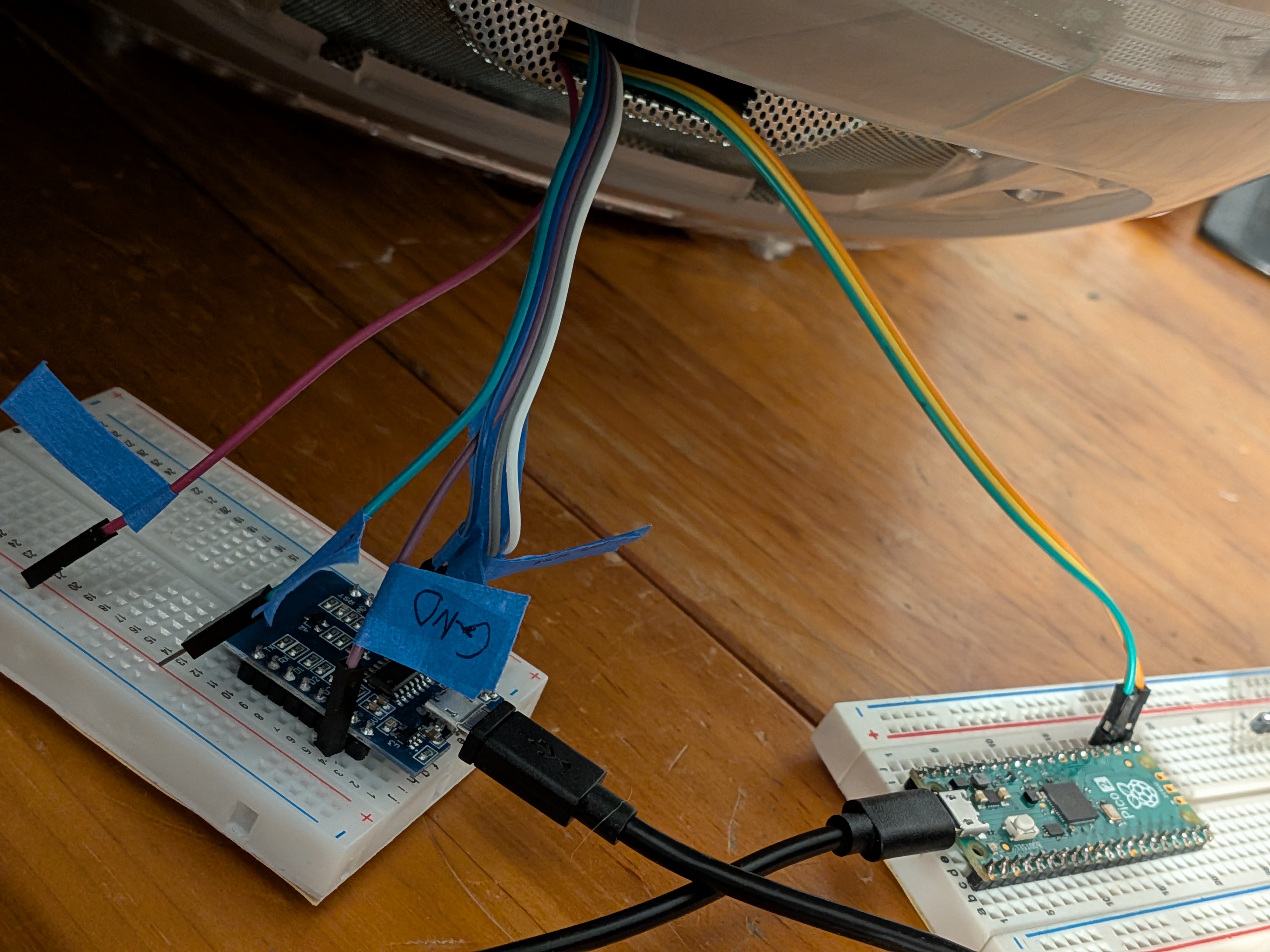the programming and debug boards with jumper wires sticking out, plugged into the back of the mac